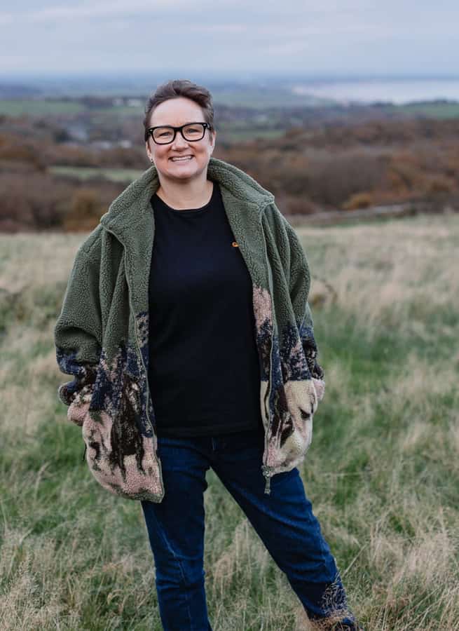 Rosie Robinson Founder WUF design Woman with short hair, glasses and a nose piercing smiling against a plain background.